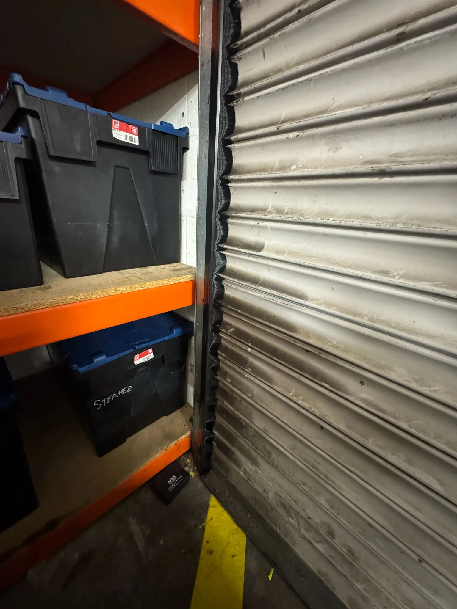 Rodent bait box and roller shutter door guard installed in a delivery and storage room
